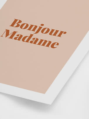 Hellrosa Poster mit weißem Rahmen und dem Schriftzug „Bonjour Madame“ in Braun
