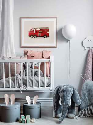 Kinderzimmer mit weißem Gitterbett und gerahmtem Bild eines roten Feuerwehrautos an der Wand