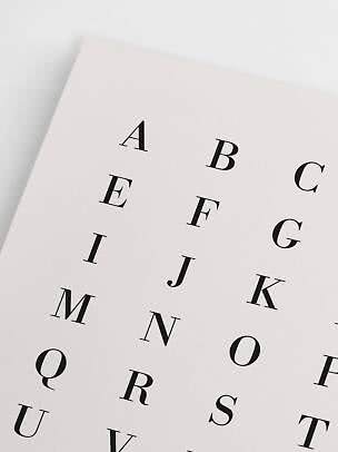 Close-up of alphabet poster with black letters on a cream background