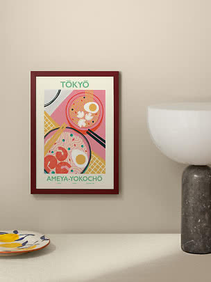 Indrammet Tokyo-plakat med farverig ramenillustration på beige væg