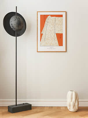Affiche d’art japonaise encadrée, motif orange et blanc, au mur à côté d’un lampadaire noir