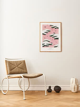 Stanza minimalista con sedia marrone, stampa rosa incorniciata e vasi sul pavimento