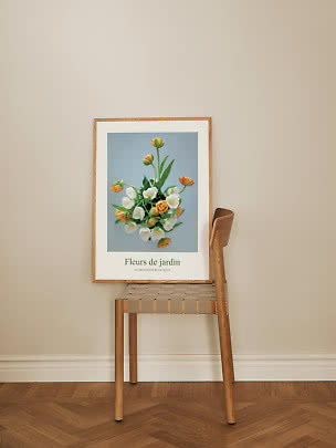 Ingelijste bloemenposter met tulpen, leunend tegen een houten stoel bij een beige muur