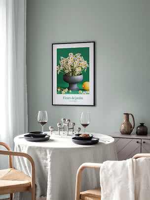 Indrammet blomsterplakat med margueritter over rundt spisebord i lys, moderne spisestue