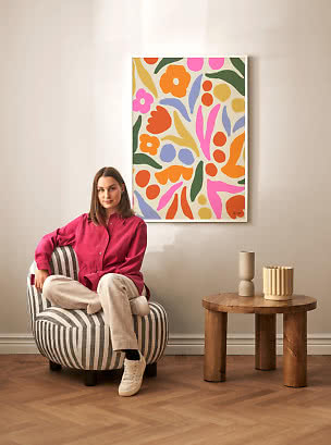 Lámina floral abstracta colorida enmarcada sobre una silla en un salón moderno