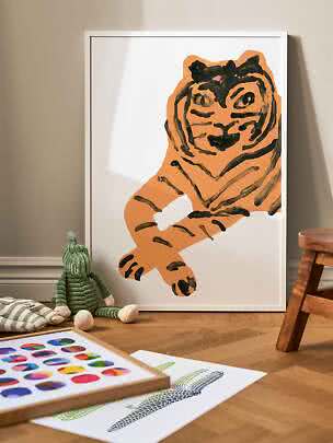 Affiche encadrée blanche avec illustration de tigre orange, posée contre le mur d'une chambre d'enfant