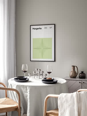 Gerahmtes Margarita-Poster mit grüner Grafik über einem gedeckten Esstisch