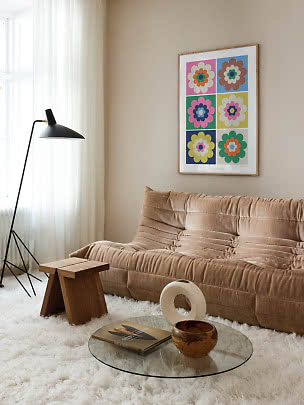 Cozy living room with beige sofa, black floor lamp, and colorful floral wall art