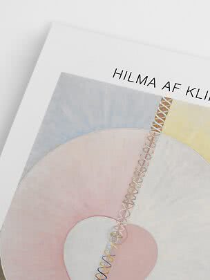 Närbild av Hilma af Klint konstposter med abstrakta pastellformer och spiral mot vit bakgrund