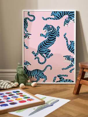 Framed poster with blue tigers on a pink background, leaning against the wall in a child's room