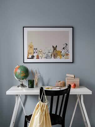 Poster incorniciato con simpatici cani e gatti sopra una scrivania bianca.