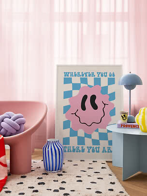 Interno colorato con sedia rosa, vaso a righe blu, lampada da tavolo blu e poster grafico