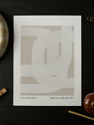 Poster astratto beige e bianco con morbide forme geometriche su tavolo scuro