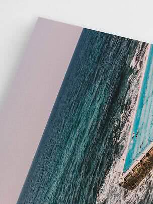 Nahaufnahme eines schrägen Prints mit Meer, Wellen und Pool vor weißem Hintergrund