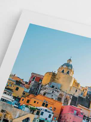 Framed photo of colorful buildings and a church dome under a clear blue sky