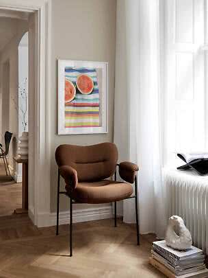 Fauteuil brun près d’une fenêtre avec affiche encadrée de pastèque sur mur beige