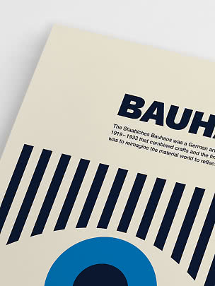 Zbliżenie plakatu Bauhaus z czarną typografią, pasami i niebieskim kołem na kremowym tle