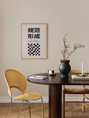 Essbereich mit rundem dunklem Holztisch, Stuhl, Vase mit Zweigen und gerahmtem Grafikposter