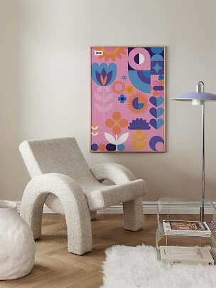 Färgglad poster med blommor och geometriska former i träram på vägg i modernt vardagsrum