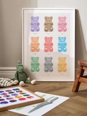 Framed poster with nine colorful gummy bears leaning against the wall on a nursery floor