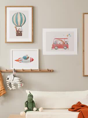Children’s room with framed animal prints, wooden coat rack and soft toys on a white bed
