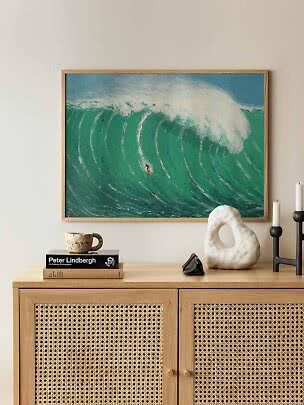 Gerahmtes Poster mit Surfer auf großer türkisfarbener Welle über einem Holzschrank