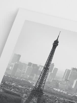 Schwarz-weißer Print des Eiffelturms vor der Pariser Skyline, schräg aufgenommen.