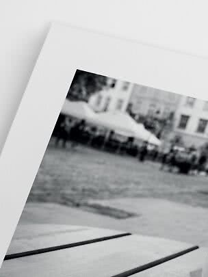 Close-up of a black-and-white photo print with white mat and blurred city scene