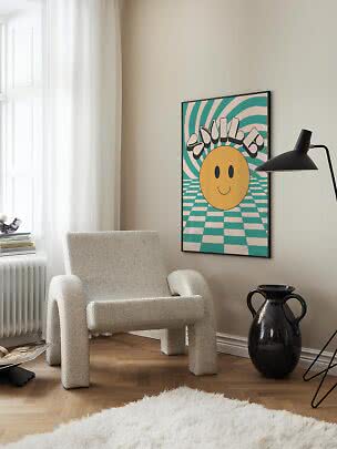 Colorful smiley poster in a black frame above a soft armchair in a bright modern room