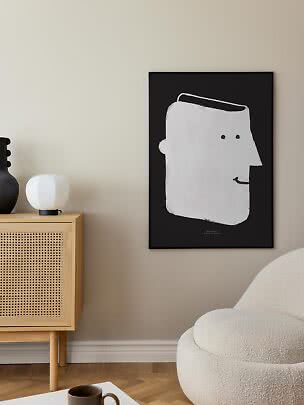 Poster con cornice nera e volto bianco astratto su parete beige in un soggiorno moderno
