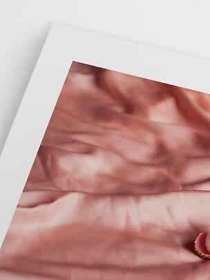 Affiche avec tissu soyeux rose abstrait et bord blanc, inclinée sur fond clair