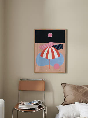 Framed abstract poster with parasol shapes and pink circles on a beige wall by a bed