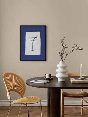 Gerahmtes Poster mit Martini-Glas und Oliven auf blauem Hintergrund über einem Esstisch