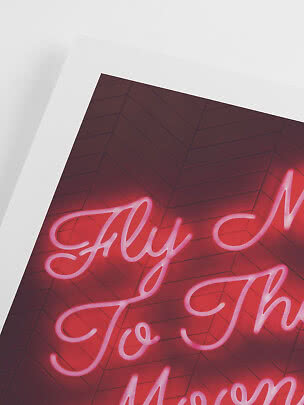 Rosa neonskylt med texten "Fly Me To The Moon" på mörk vägg med fiskbensmönster