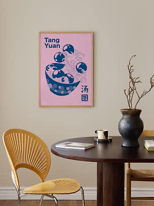 Lyserød indrammet Tang Yuan-plakat med blå skålmotiv over et spisebord