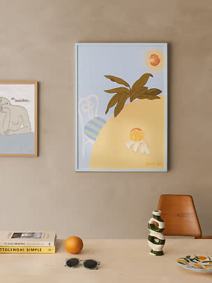 Gerahmtes abstraktes Poster mit Zitrusfrüchten und Blättern an beigefarbener Wand über hellem Tisch.