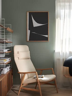Poster astratto bianco e nero con cornice in legno sopra una poltrona beige