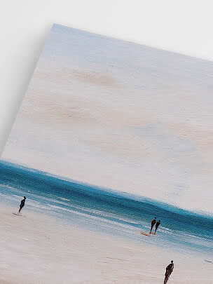 Close-up of canvas with minimalist beach scene in blue tones and small human figures