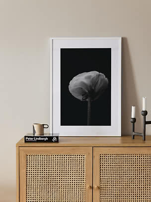Affiche florale noir et blanc encadrée sur buffet en bois avec bougeoir et tasse