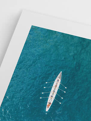 Close-up of art print showing an aerial view of a rowing boat on turquoise water