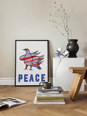 Gerahmtes Peace-Poster mit buntem Vogel, an eine Wand auf Holzboden gelehnt