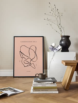 Stilleben med abstrakt rosa poster, bokstapel, kopp, svart vas och vit marmorpiedestal