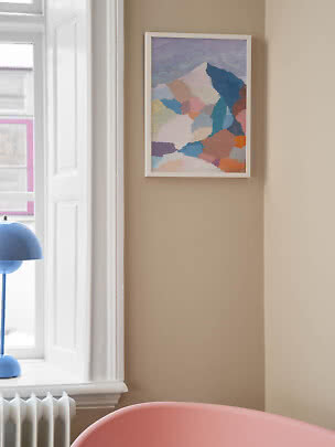 Affiche abstraite encadrée aux tons pastel sur mur beige près d’une fenêtre