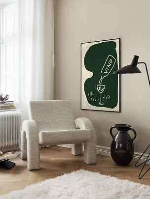 Gemütliche Ecke mit cremefarbenem Sessel, schwarzer Stehlampe und grünem abstraktem Wandposter