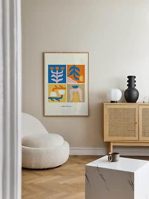 Kleurrijke botanische poster in houten lijst aan beige muur in moderne woonkamer