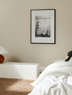 Zwart ingelijste kunstprint met zwart-witfoto van klassieke sculpturen aan beige muur