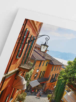 Angled photo of colorful houses on a cobblestone street with balconies and lanterns