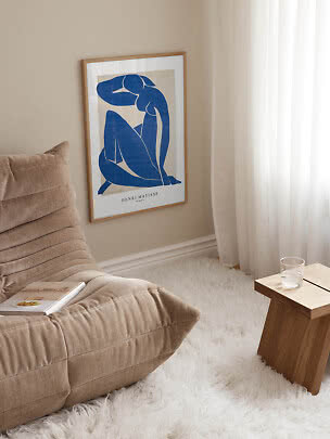 Indrammet Henri Matisse-plakat med blå siddende figur på beige væg i lys stue