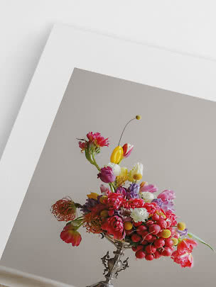 Bunter Blumenstrauß mit Tulpen und roten Radieschen in einer verzierten Silbervase