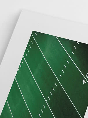 Primo piano di un poster con campo da football americano verde e linee bianche